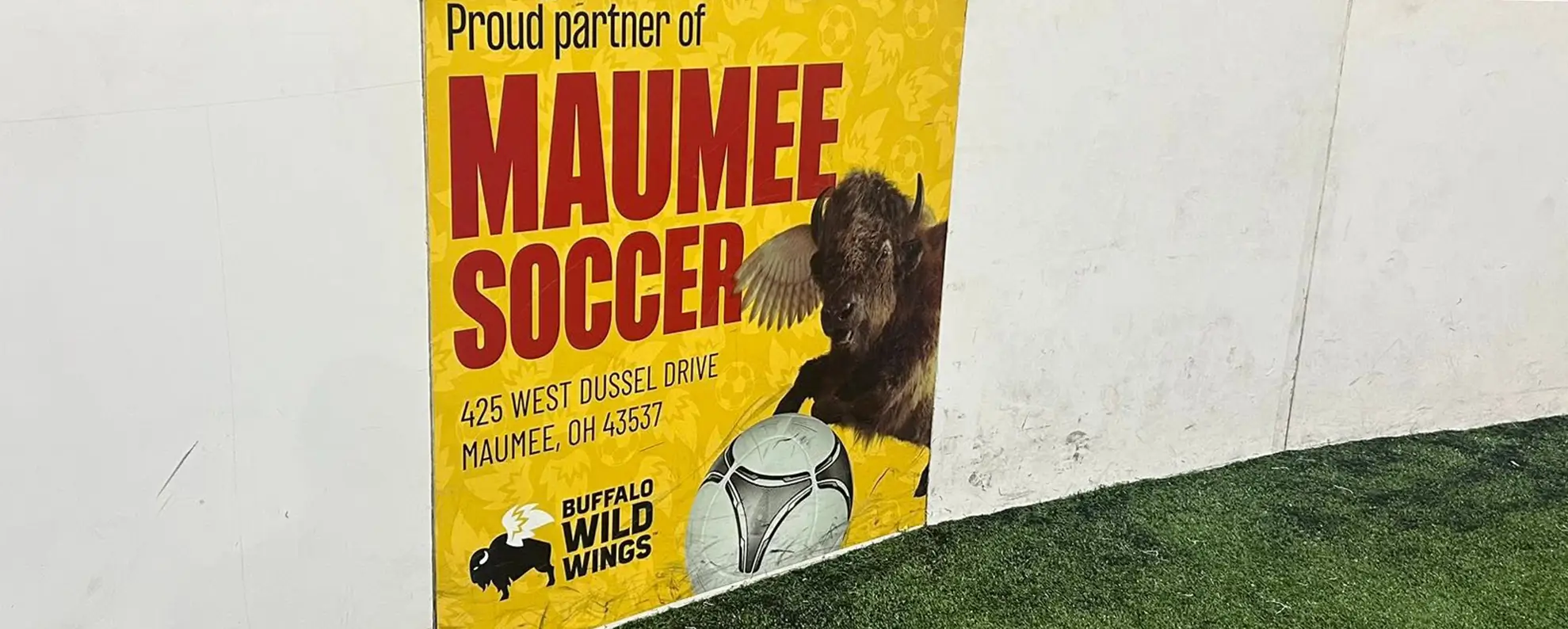 Buffalo Wild Wings advertising board beside indoor turf